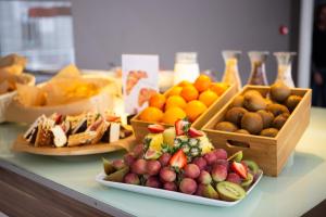 a table topped with plates of fruit and baskets of bread at Ibis Kaunas Centre in Kaunas