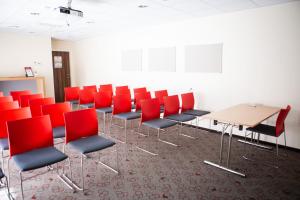 a conference room with red chairs and a table at Ibis Kaunas Centre in Kaunas