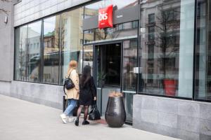 two women walking in front of a store window at Ibis Kaunas Centre in Kaunas