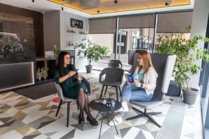 two women sitting in chairs in an office at Ibis Kaunas Centre in Kaunas