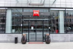 two vases in front of a building with a bus sign at Ibis Kaunas Centre in Kaunas