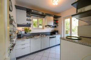 a large kitchen with white cabinets and a sink at Diana Villa in Oggebbio
