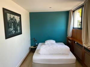 - une chambre dotée d'un lit avec un mur bleu dans l'établissement Appartement atypique Epinal Gare, à Épinal
