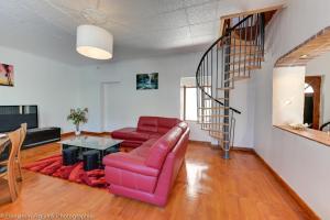 a living room with a red couch and a table at Villa Lamartine in Aix-les-Bains
