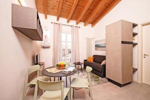 a living room with a table and chairs and a couch at Corte Fasanella 78 in Toscolano Maderno