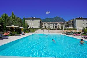 a group of people swimming in a large swimming pool at Corte Fasanella 78 in Toscolano Maderno