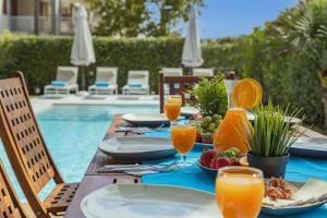 a table with plates of food and orange juice at Villa Plomer Serra in Playa de Muro