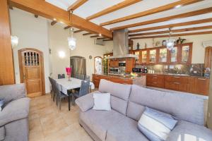 a living room with a couch and a table and a kitchen at Villa Plomer Serra in Playa de Muro +47 photos