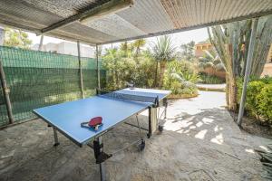 a blue ping pong table with a red hat on it at Villa Plomer Serra in Playa de Muro