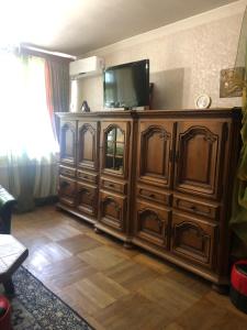 a large wooden entertainment center with a television on top at Homestay Happiness in Tbilisi City