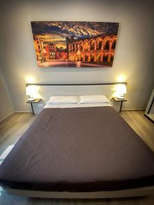 ヴェローナにあるホテル アレーナの壁画が飾られた部屋のベッド1台