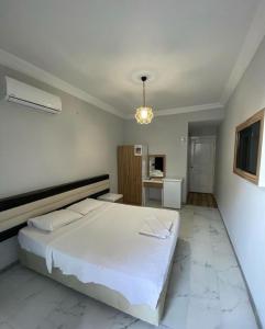 een slaapkamer met een groot wit bed in een kamer bij Günaydın Otel Alanya in Alanya
