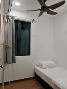 a bedroom with a ceiling fan and a window at Lovely Sweet Home in Johor Bahru