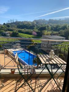 balcón con mesa y piscina en Ático con piscina, en Porto de Espasante