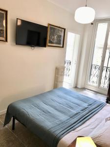 een slaapkamer met een bed en een flatscreen-tv aan de muur bij Casa Cairoli in Milaan
