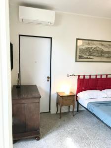 een slaapkamer met een bed en een tafel met een lamp bij Casa Cairoli in Milaan