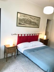 een slaapkamer met een bed met een rood hoofdeinde en een tafel bij Casa Cairoli in Milaan