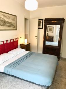 een slaapkamer met een bed met een rood hoofdeinde en een spiegel bij Casa Cairoli in Milaan