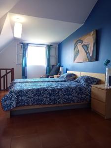 1 dormitorio con 1 cama con pared azul en Scenic Comfort, en Ponta Delgada