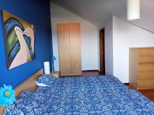 蓬塔德爾加達的住宿－Scenic Comfort，卧室配有一张床,墙上挂有绘画作品