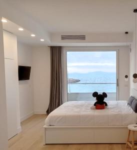 a teddy bear sitting on a bed in a bedroom at Boutique Lungomare in Porto Torres