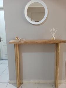 a wooden console table with a mirror on the wall at Kypseli studio rhodes in Kremasti