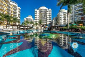 una gran piscina con edificios altos en el fondo en N1401 VISTAMAR Amplo Club Praia Beto Carrero 4qrts, en Penha