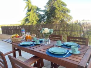 uma mesa de madeira com placas azuis e um vaso de flores em Sol de Ferragudo em Ferragudo