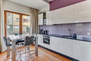 a kitchen with a table and chairs in a room at Executive Apartment with Sauna by Grand Apartments in Sopot