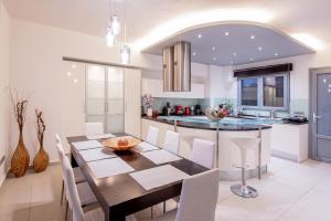 a kitchen and dining room with a table and chairs at Dias Luxury Villa in Koskinou