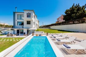 a villa with a swimming pool and lounge chairs at Dias Luxury Villa in Koskinou