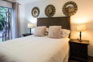 a bedroom with a large bed with two mirrors on the wall at Willow Cottage in Dullstroom