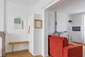 un soggiorno con divano rosso e sedia di Le Passage - appartement lumineux à La Madeleine ad Albi