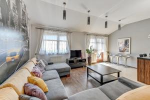 a living room with a couch and a table at Grand Apartments - Neptun Park. in Gdańsk