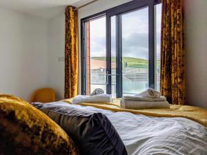 a bedroom with a bed and a large window at 8 Middlecombe - Luxury Apartment at Byron Woolacombe, only 4 minute walk to Woolacombe Beach! in Woolacombe
