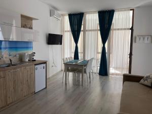 Il comprend une cuisine et un salon avec une table et des chaises. dans l'établissement SEA Apartment Maria Balchik, à Balchik