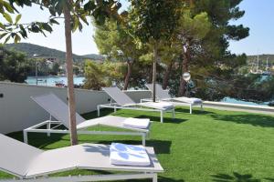 a row of white chairs sitting on a lawn at Premier Laguna Apartment in Lovište