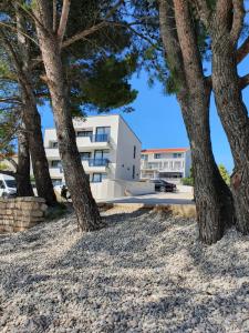 a white building with trees in front of it at Premier Laguna Apartment in Lovište