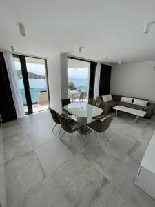 a living room with a table and chairs and the ocean at Premier Laguna Apartment in Lovište