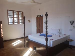 a bedroom with a large bed in a room at Wow Beach House in Jambiani +16 photos