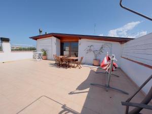 een patio met een tafel en stoelen op een dak bij Appartamento con vista sul Gargano in Vico del Gargano