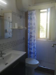 a bathroom with a toilet and a sink and a window at Il Gelso nella Valle in Agrigento