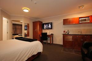 una camera d'albergo con letto, scrivania e cucina di City Corporate Motor Inn a Palmerston North