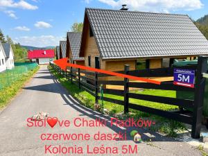 a house with a fence next to a road at Stolove Chatki Radków in Radków