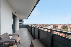 a balcony with chairs and a view of a city at Grand Apartments - Luxury apartment on the 11th floor with a view of the Old Town in Gdańsk