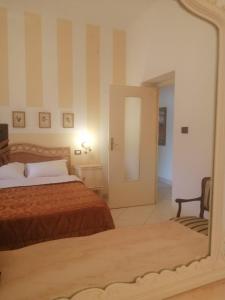 a bedroom with a bed and a mirror at Il Gelso nella Valle in Agrigento
