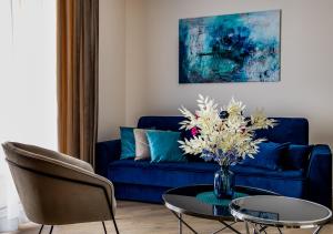 sala de estar con sofá azul y mesa con flores en Si Centrum Lipowa, en Białystok