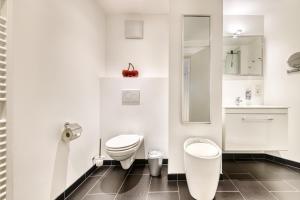 a white bathroom with a toilet and a sink at Ferienwohnung Zentral mit Panorama-Sonnenterrasse by A-Appartments in Brand