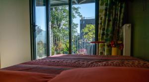 a bedroom with a bed and a large window at Chambre d'hôtes de charme à Montreuil-Paris in Montreuil