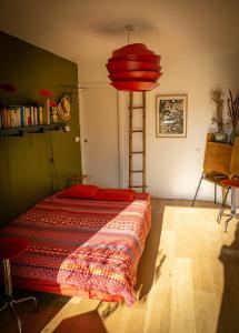 una camera con 2 letti e una lampada rossa di Chambre d'hôtes de charme à Montreuil-Paris a Montreuil